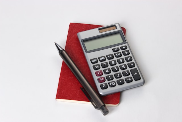 rekenmachine en pen op rode schrift